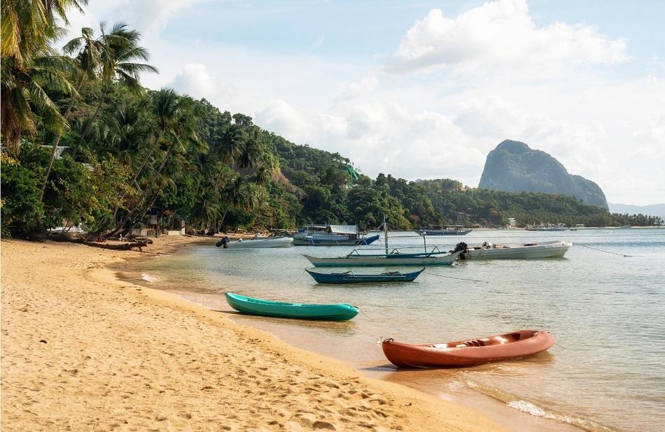 Corong-Corong beach in El Nido, with outrigger boats drawn up on the sand.