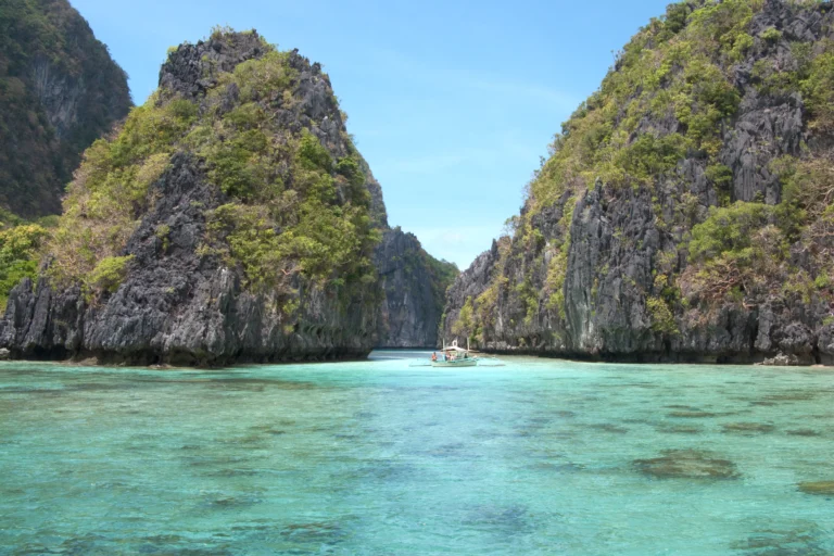A sheltered island lagoon ringed by limestone karst in Bacuit Bay, El Nido.