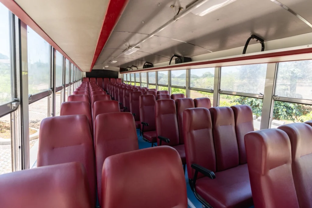 Cherry Bus Economy seating: maroon vinyl seats with sliding windows and no air conditioning.