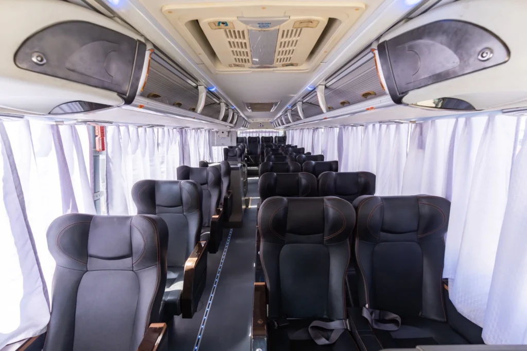 Cherry Bus Lazyboy Elite recliner seats with curtains and seatbelts.