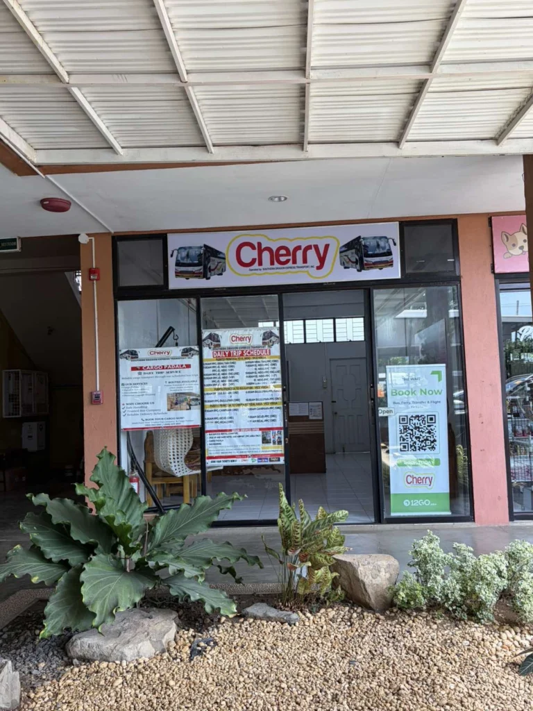 The Cherry ticket office frontage in Puerto Princesa, showing the daily trip schedule, Cargo Padala poster and booking QR code in the window.