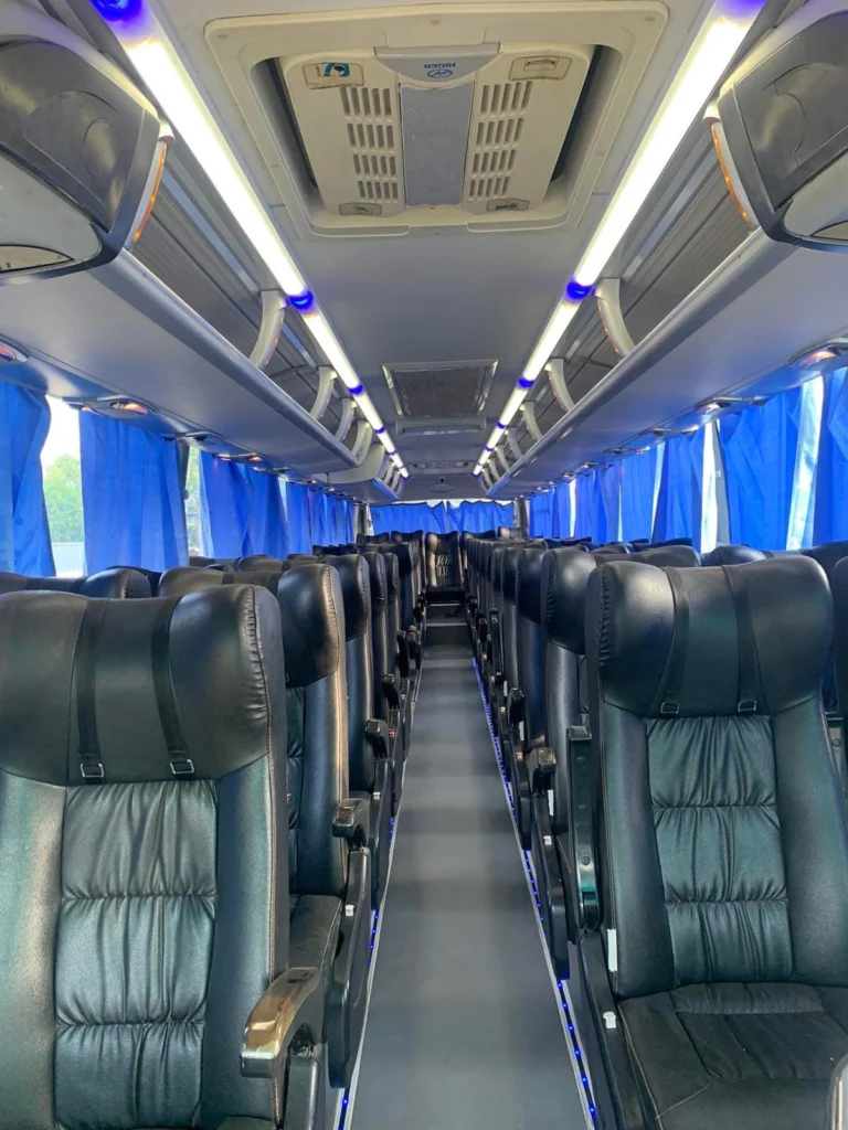 Cherry Bus Regular AC interior: reclining seats, blue curtains and overhead air conditioning.